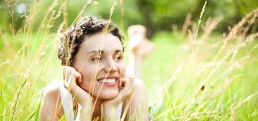 A woman laying in a field of tall grass