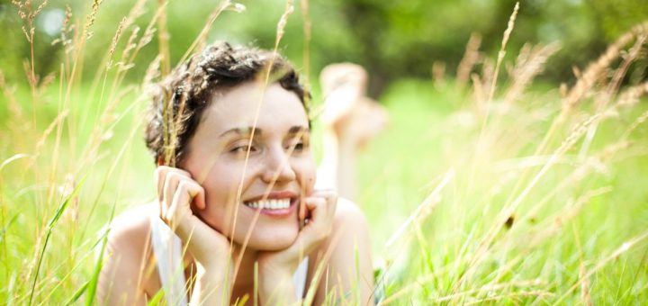 A woman laying in a field of tall grass