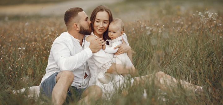 Happy family enjoying quality time in a serene meadow setting.
